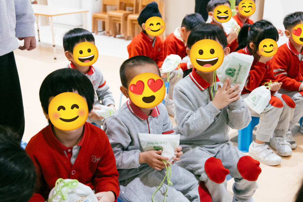 Clean the World Asia charity event at Hong Kong kindergarten. Kids (with faces covered) holding their hygiene kits.