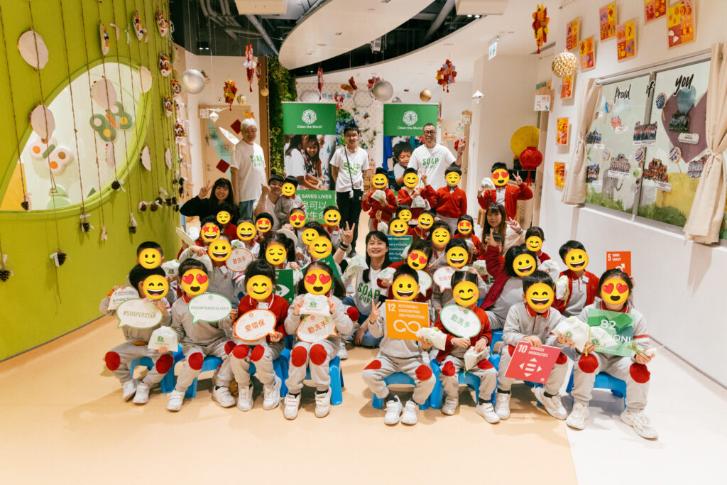 Clean the World Asia – Group photo with kindergarten students (faces covered) and the team. Hong Kong SDG charity event.