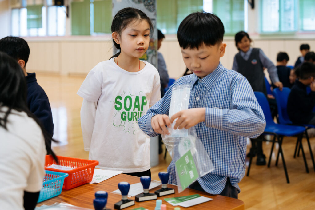 2 school children packing hygiene kits • Clean the World Asia • Green hygiene education events with Hong Kong charity